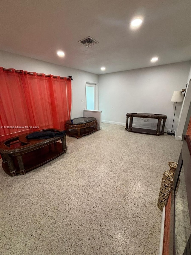 living area featuring baseboards, speckled floor, visible vents, and recessed lighting