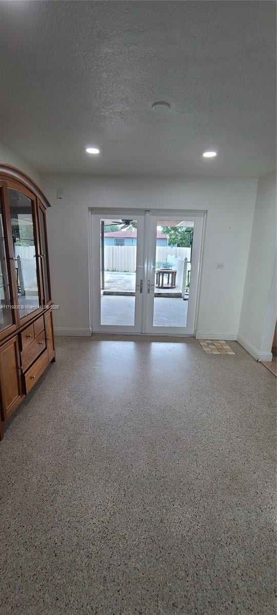 spare room with light speckled floor, french doors, recessed lighting, a textured ceiling, and baseboards