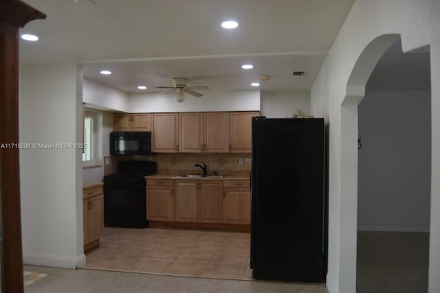 kitchen with recessed lighting, a sink, light countertops, decorative backsplash, and black appliances