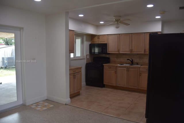 kitchen with tasteful backsplash, recessed lighting, light countertops, a sink, and black appliances