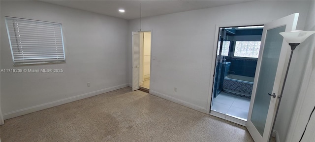 spare room featuring recessed lighting, baseboards, and speckled floor