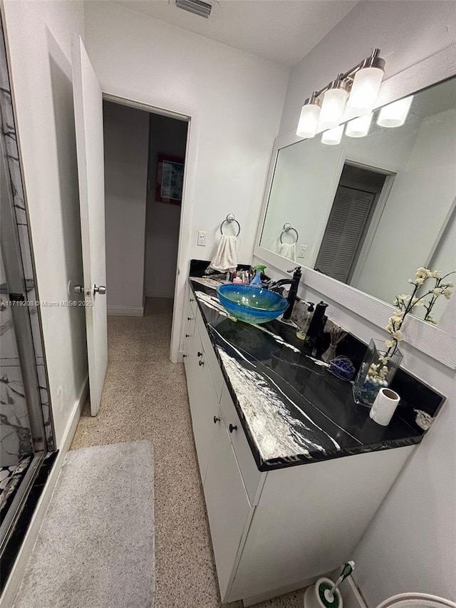 bathroom with vanity, a shower, and speckled floor