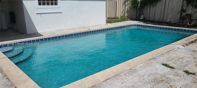 outdoor pool featuring fence