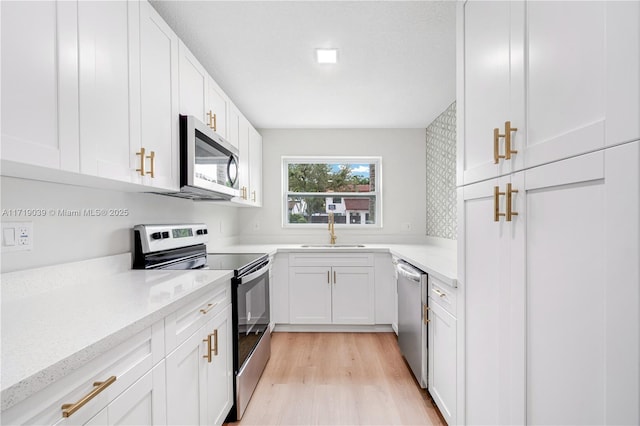 kitchen featuring appliances with stainless steel finishes, sink, and white cabinets