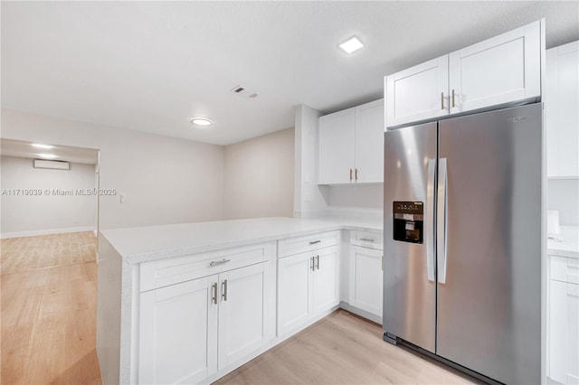 kitchen featuring white cabinetry, light wood-type flooring, kitchen peninsula, and stainless steel refrigerator with ice dispenser