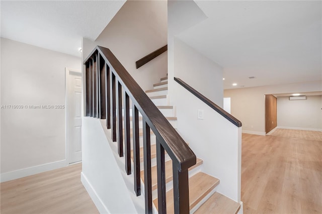 stairs featuring a wall mounted air conditioner and hardwood / wood-style floors