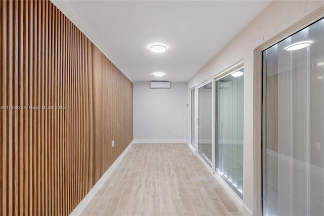 hall with a wall mounted air conditioner and light hardwood / wood-style flooring