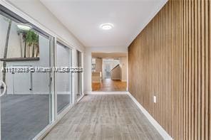 corridor featuring wood-type flooring and wooden walls