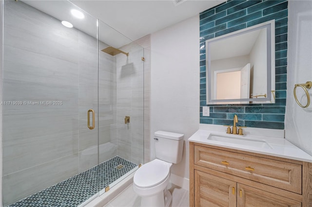 bathroom with a shower with door, vanity, decorative backsplash, and toilet