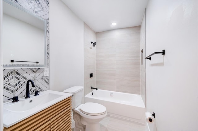 full bathroom featuring vanity, tiled shower / bath, backsplash, and toilet