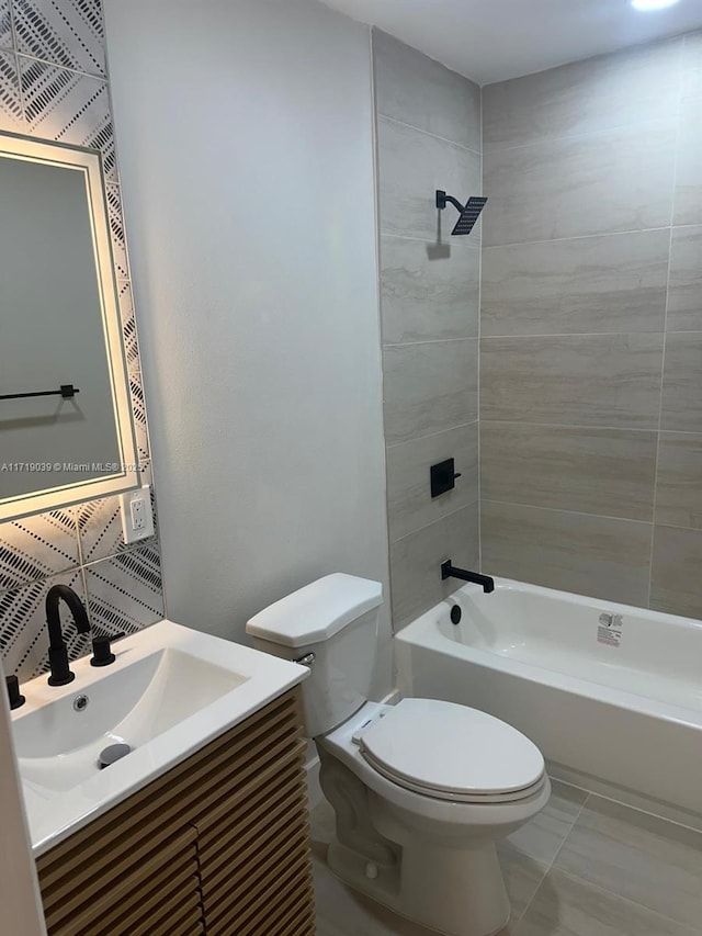 full bathroom with vanity, tiled shower / bath, and toilet