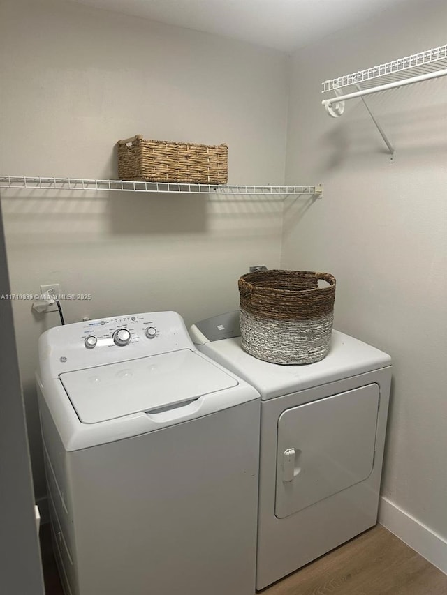 clothes washing area featuring hardwood / wood-style floors and washer and clothes dryer