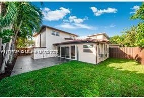 back of property featuring a patio and a lawn