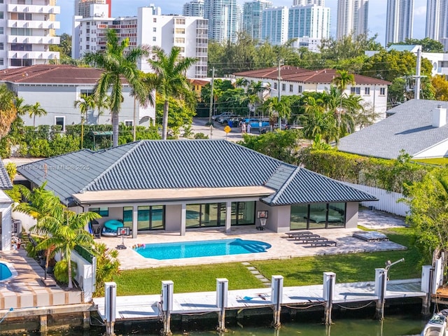 back of house with a lawn, a patio area, and a water view