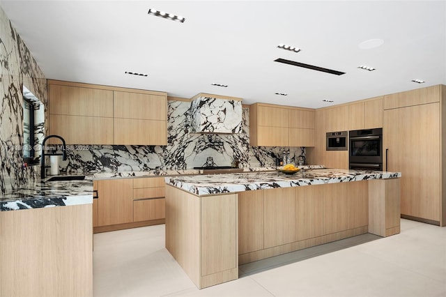 kitchen featuring light brown cabinets, a center island, double oven, and sink