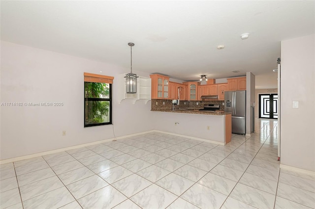 kitchen with tasteful backsplash, decorative light fixtures, dark stone countertops, kitchen peninsula, and stainless steel appliances