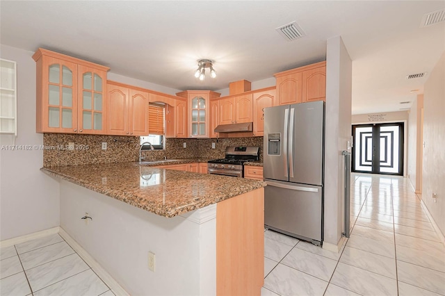 kitchen featuring sink, tasteful backsplash, appliances with stainless steel finishes, kitchen peninsula, and stone counters