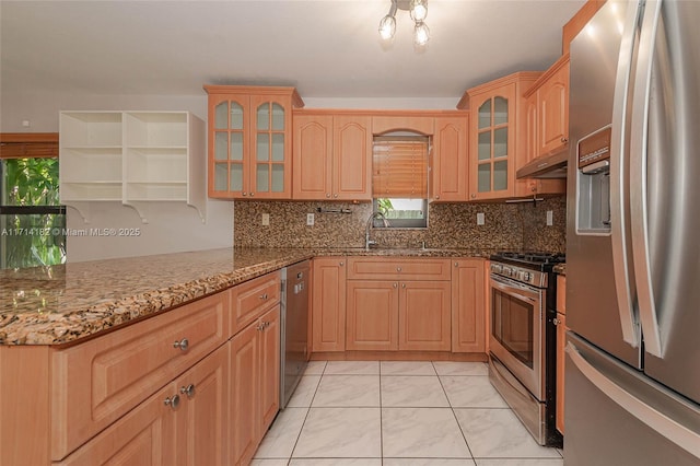 kitchen featuring tasteful backsplash, appliances with stainless steel finishes, stone countertops, and sink