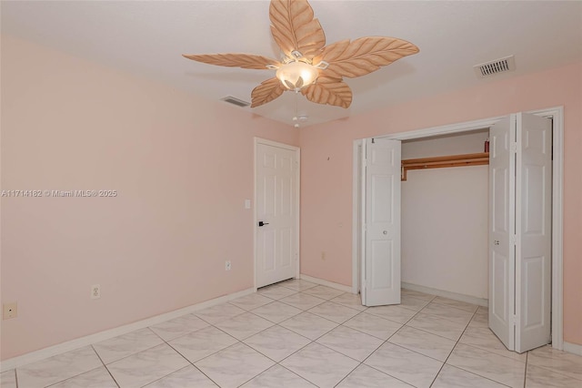 unfurnished bedroom with light tile patterned floors, a closet, and ceiling fan