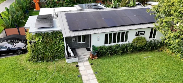 view of front of home with a front lawn and solar panels