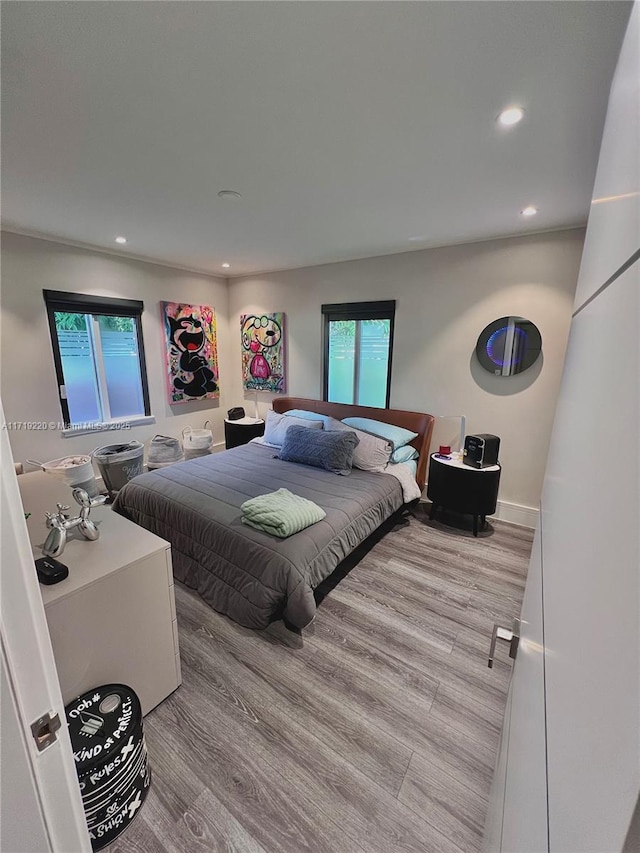 bedroom with light hardwood / wood-style flooring and multiple windows