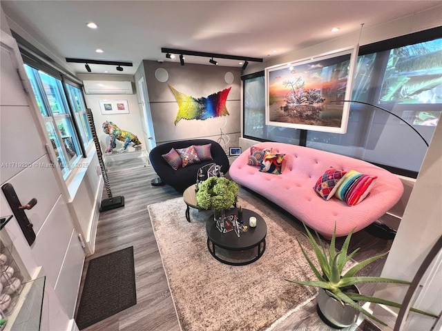 game room with a wall mounted air conditioner and hardwood / wood-style flooring