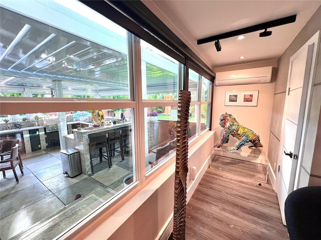 hall with hardwood / wood-style flooring and a wall unit AC