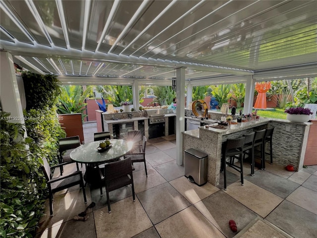 view of patio / terrace featuring an outdoor kitchen and a bar