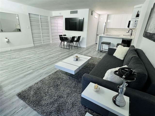 living room with sink and light hardwood / wood-style flooring