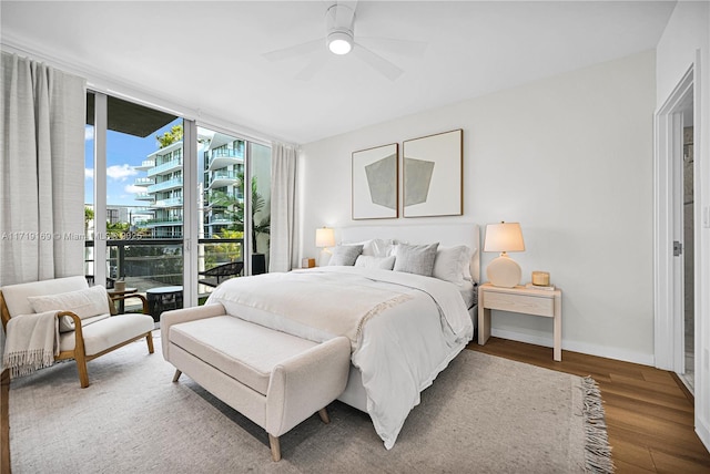 bedroom with access to exterior, ceiling fan, wood-type flooring, and a wall of windows