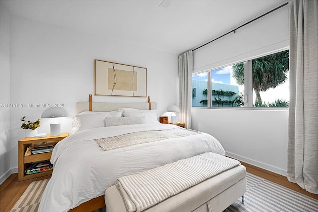 bedroom featuring light hardwood / wood-style floors and a water view