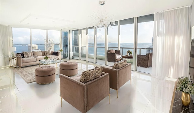 sunroom / solarium featuring a notable chandelier and a water view