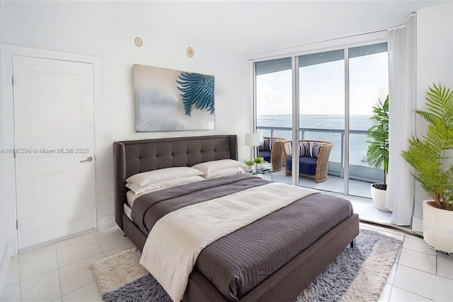 tiled bedroom with access to exterior, a water view, and expansive windows