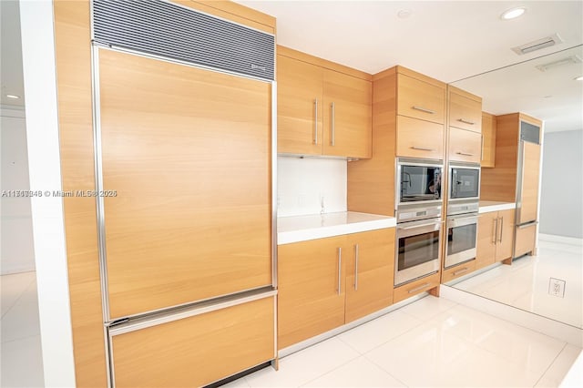 495 Brickell Ave Unit 2301, Miami, FL 33131 - kitchen featuring built in appliances, light brown cabinetry, light countertops, light tile patterned floors, and recessed lighting