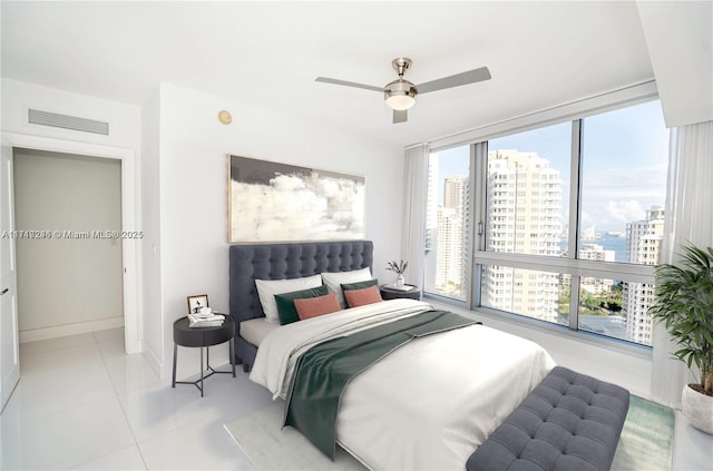 tiled bedroom featuring ceiling fan and floor to ceiling windows