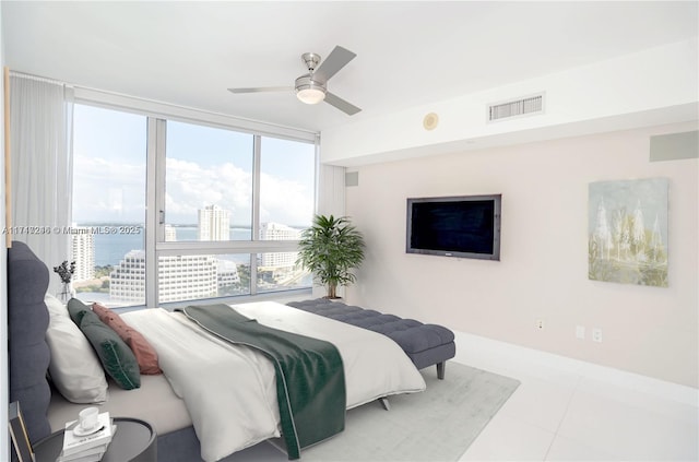 tiled bedroom with expansive windows, a water view, and ceiling fan