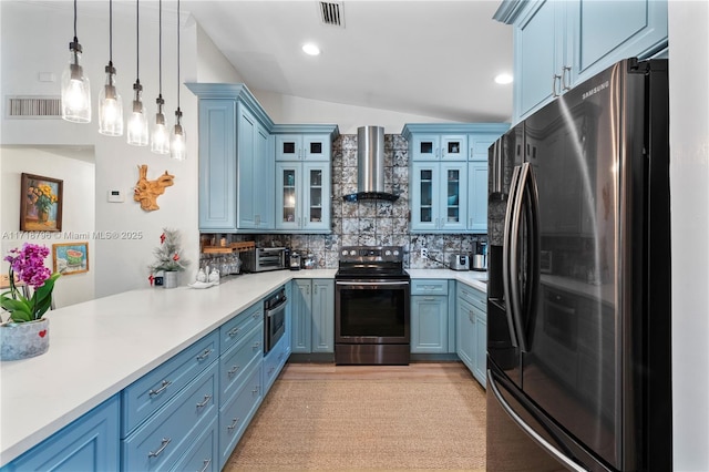 kitchen featuring decorative light fixtures, lofted ceiling, backsplash, wall chimney range hood, and stainless steel appliances