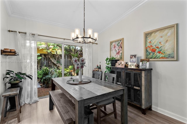 dining area featuring hardwood / wood-style flooring, ornamental molding, and a notable chandelier