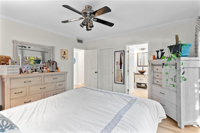 bedroom with ensuite bath, ceiling fan, crown molding, and light hardwood / wood-style flooring