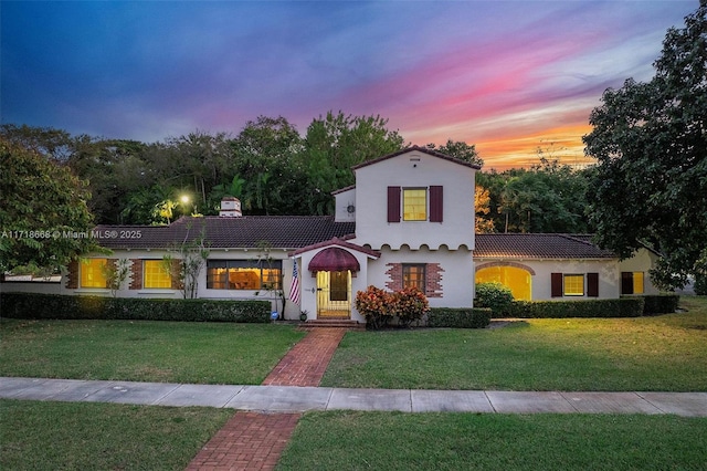 mediterranean / spanish home with a yard