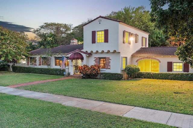 mediterranean / spanish-style home with a lawn