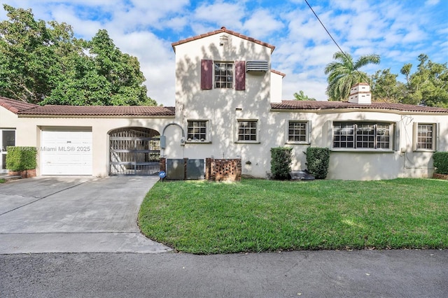 mediterranean / spanish house featuring a front yard and a garage