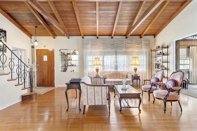 living room featuring vaulted ceiling with beams, light hardwood / wood-style flooring, and wooden ceiling