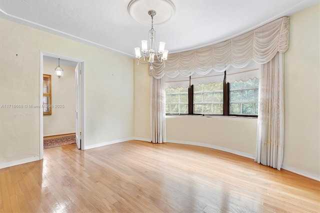 unfurnished room with wood-type flooring and an inviting chandelier