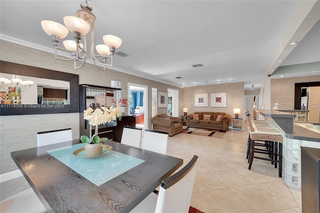 dining space featuring crown molding, light tile patterned floors, and an inviting chandelier