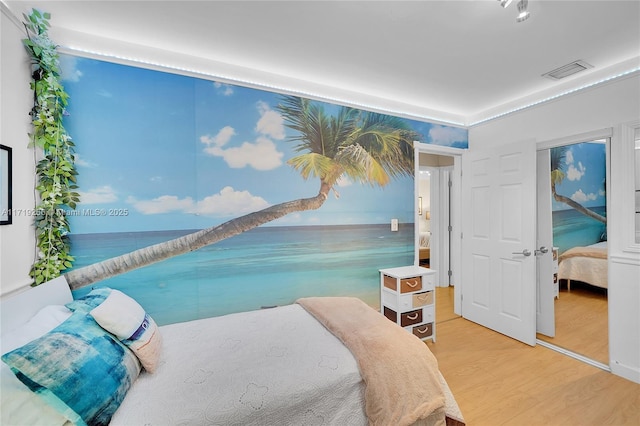 bedroom with a water view and hardwood / wood-style flooring