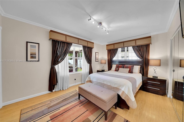 bedroom with light hardwood / wood-style floors, multiple windows, and crown molding