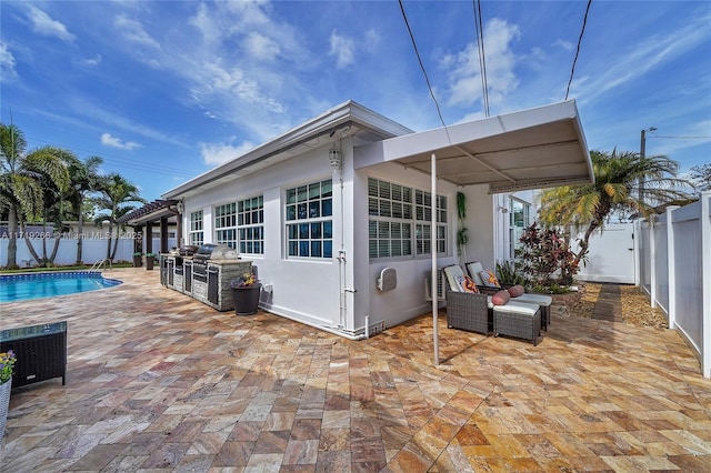 rear view of property featuring an outdoor living space, a patio area, and a fenced in pool