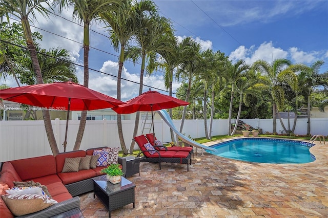 view of swimming pool with a water slide, a patio, and an outdoor hangout area