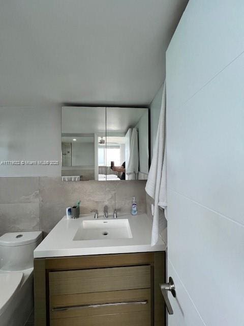 bathroom with vanity, tile walls, and toilet